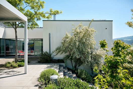 Terrasse mit moderner Pergola, Sitzgruppe und Panoramablick über Felder und Berge