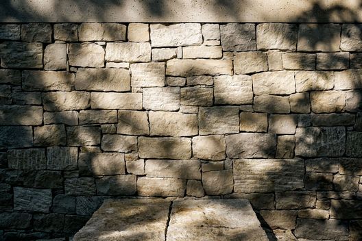 Detailaufnahme einer handgerichteten Kalksteinmauer mit natürlichem Schattenwurf