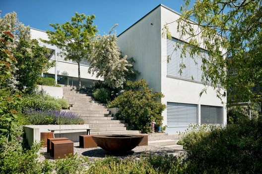 Terrassierter Hanggarten mit Treppe, Feuerring und vielfältiger Stauden- und Gehölzbepflanzung
