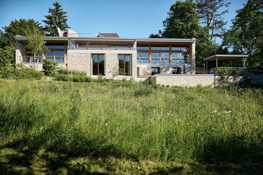 Hochwertiger Neubau mit Natursteinfassade, grosser Terrasse und blühender Wiesenfläche